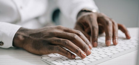 Man's hands typing on keyboard